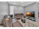 Comfortable living room featuring leather seating, plush rug, and modern entertainment center with television at 9444 W Roma Ave, Phoenix, AZ 85037