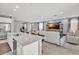 Bright, open-concept living space featuring light wood flooring, a sleek kitchen island and comfortable seating at 9444 W Roma Ave, Phoenix, AZ 85037