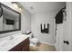 Clean bathroom with a sink vanity, toilet, and shower with white and black accents at 9719 W Heber Rd, Tolleson, AZ 85353