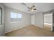 This well-lit bedroom features a large window, neutral carpet, and a ceiling fan at 9719 W Heber Rd, Tolleson, AZ 85353