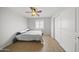 This cozy bedroom features wood-look floors, a ceiling fan, and a window with stylish shutters at 9719 W Heber Rd, Tolleson, AZ 85353