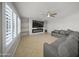 Inviting living room with fireplace, ceiling fan, and plantation shutters allowing in natural light at 9719 W Heber Rd, Tolleson, AZ 85353