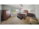 This main bedroom features a large window, ceiling fan, and luxurious wood furniture at 9719 W Heber Rd, Tolleson, AZ 85353