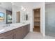 Bathroom featuring double sinks, spacious vanity, walk-in shower, and well-lit mirror at 100 W Northern Ave # 12, Phoenix, AZ 85021