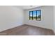 Bright bedroom with hardwood floors, white walls and a view outside the window at 100 W Northern Ave # 12, Phoenix, AZ 85021