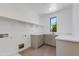 A well-lit laundry room with storage shelving, a quartz countertop, and neutral paint at 100 W Northern Ave # 12, Phoenix, AZ 85021