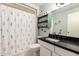 Bathroom featuring tile flooring, black granite countertops, and floral shower curtain at 10161 W Thunderbird Blvd, Sun City, AZ 85351
