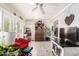Cozy sunroom with whitewashed wood flooring, ample plants, and a red armchair at 10161 W Thunderbird Blvd, Sun City, AZ 85351