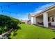 Beautiful backyard featuring lush green turf, manicured hedges, and covered patio at 10206 E Texas Ave, Mesa, AZ 85212