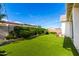 Beautiful backyard featuring lush green turf, manicured hedges, and charming string lights at 10206 E Texas Ave, Mesa, AZ 85212