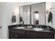 Modern bathroom with dual sinks, dark cabinetry, sleek mirrors, and contemporary lighting fixtures at 10206 E Texas Ave, Mesa, AZ 85212