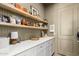 Hallway featuring a white cabinet and shelves with warm, inviting decor at 10206 E Texas Ave, Mesa, AZ 85212