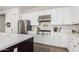 Charming kitchen featuring stainless steel appliances, white cabinetry, quartz countertops, and hardwood floors at 10206 E Texas Ave, Mesa, AZ 85212