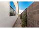 Paved side yard showcasing clean lines, flowering vines and ample space to walk along the side of the home at 10206 E Texas Ave, Mesa, AZ 85212