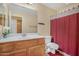 Bathroom features a single sink, red shower curtain, tile flooring and toilet at 1049 N Monterey St, Gilbert, AZ 85233