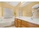 Bathroom features a soaking tub, double sinks with wood cabinets, and lots of natural light at 1049 N Monterey St, Gilbert, AZ 85233