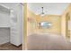 Bedroom features a walk-in closet, neutral carpet, a ceiling fan and a bright window at 1049 N Monterey St, Gilbert, AZ 85233