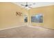 Spacious primary bedroom featuring a ceiling fan, neutral carpet, and abundant natural light at 1049 N Monterey St, Gilbert, AZ 85233
