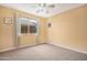 Bedroom features a bright window with patterned curtains, ceiling fan and carpet at 1049 N Monterey St, Gilbert, AZ 85233