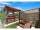 Charming pergola with dining set, adjacent to raised garden beds, perfect for outdoor relaxation at 1049 N Monterey St, Gilbert, AZ 85233