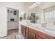 Bathroom featuring double sinks, a large mirror, and a walk-in closet at 11611 N 149Th Ln, Surprise, AZ 85379