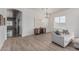 Bright living room with hardwood floors, white walls, large windows, and a cozy grey sofa at 11611 N 149Th Ln, Surprise, AZ 85379