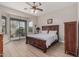 Bright primary bedroom featuring a ceiling fan, wood flooring, and a sliding glass door at 11611 N 149Th Ln, Surprise, AZ 85379