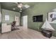 Spacious home office with green walls, light wood floors, a ceiling fan, and an adjacent room at 11611 N 149Th Ln, Surprise, AZ 85379