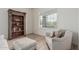 Cozy sitting area with a decorative bookcase, a comfy chair, a window, and wood flooring at 11611 N 149Th Ln, Surprise, AZ 85379