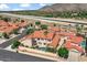 Stunning aerial view of the community with red-tiled roofs, a canal, and mountain views in the background at 11889 N 113Th Pl, Scottsdale, AZ 85259