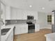 Bright kitchen featuring white cabinets, stainless steel appliances, and wood flooring at 11889 N 113Th Pl, Scottsdale, AZ 85259