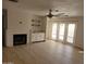 Bright living room with a fireplace, built-in bar, and french doors leading to the patio and backyard at 11889 N 113Th Pl, Scottsdale, AZ 85259
