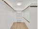 Spacious walk-in closet with built in shelving and wooden rods for hanging clothes at 11889 N 113Th Pl, Scottsdale, AZ 85259