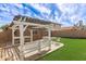Lush backyard features a covered pergola with a seating area, perfect for outdoor entertaining at 12230 W Larkspur Rd, El Mirage, AZ 85335