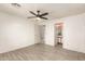 Bright bedroom featuring plank flooring, ceiling fan, and an en-suite bathroom at 12230 W Larkspur Rd, El Mirage, AZ 85335