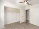 Bright bedroom with a walk-in closet, ceiling fan, and light gray floors at 12230 W Larkspur Rd, El Mirage, AZ 85335