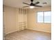 Bedroom features built in shelving, light wood floors, ceiling fan and a window at 12230 W Larkspur Rd, El Mirage, AZ 85335