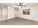 Bedroom with modern vinyl plank flooring, built-in shelving, and a ceiling fan at 12230 W Larkspur Rd, El Mirage, AZ 85335
