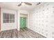Bright bedroom with a ceiling fan and a closet with green tropical wallpaper at 12230 W Larkspur Rd, El Mirage, AZ 85335