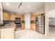 Well-lit kitchen featuring stainless steel appliances, tile countertops, and ample cabinet space at 12230 W Larkspur Rd, El Mirage, AZ 85335