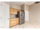 Kitchen with tile floor, wood cabinets, stainless steel refrigerator, and granite countertops at 12230 W Larkspur Rd, El Mirage, AZ 85335