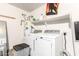 Laundry room with washer, dryer, utility sink and shelving, and gray flooring at 12230 W Larkspur Rd, El Mirage, AZ 85335