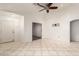 Bright living room featuring tile flooring, ceiling fan, and multiple doorways at 12230 W Larkspur Rd, El Mirage, AZ 85335