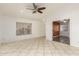 Bright living room featuring tile flooring, ceiling fan, and multiple doorways at 12230 W Larkspur Rd, El Mirage, AZ 85335