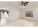 Bright living room featuring tile flooring, ceiling fan, and sliding glass doors at 12230 W Larkspur Rd, El Mirage, AZ 85335
