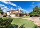 Expansive backyard with a putting green, covered patio, second story deck and desert landscaping at 12853 E Yucca St, Scottsdale, AZ 85259