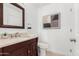 This bathroom offers a vanity with a stone counter, a mirror, and a toilet at 12853 E Yucca St, Scottsdale, AZ 85259