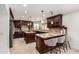 Gourmet kitchen features dark wood cabinetry, granite counters, stainless appliances, and seating at island at 12853 E Yucca St, Scottsdale, AZ 85259