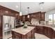 Gourmet kitchen features dark wood cabinetry, granite counters, stainless appliances, and island at 12853 E Yucca St, Scottsdale, AZ 85259