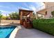 A backyard pool area with a stone-pillared pergola and wooden stairs at 12853 E Yucca St, Scottsdale, AZ 85259